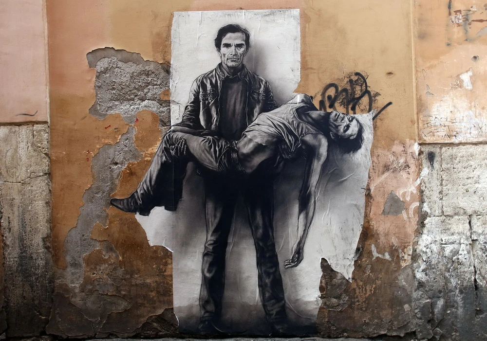 Pasolini, der Märtyrer: wandbilder eines unbekannten Künstlers, die 2015 an verschiedenen orten in Rom auftauchten, zeigen den Künstler, sich selbst als Leichnam in den Armen tragend (© IMAGO/Insidefoto)